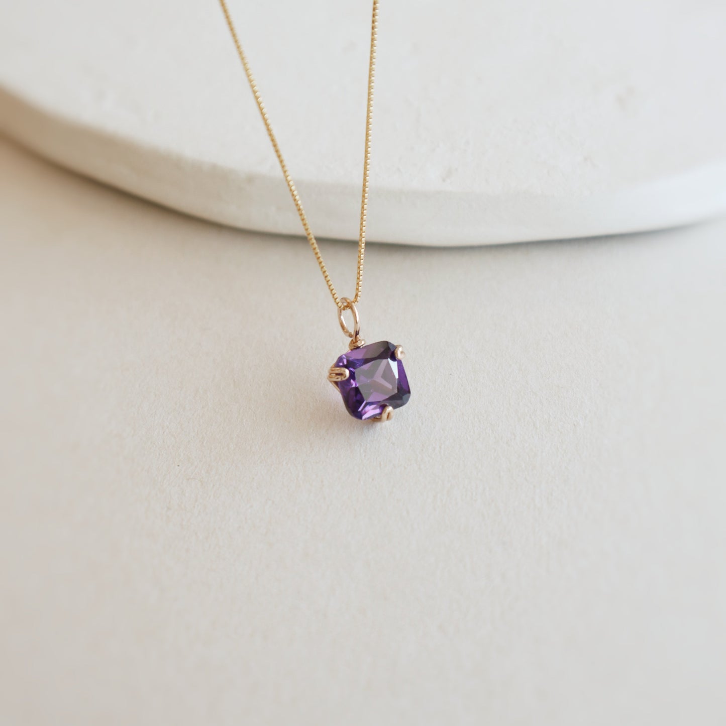 Necklace with a purple gemstone pendant on a white background