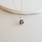 Necklace with a purple gemstone pendant on a white background