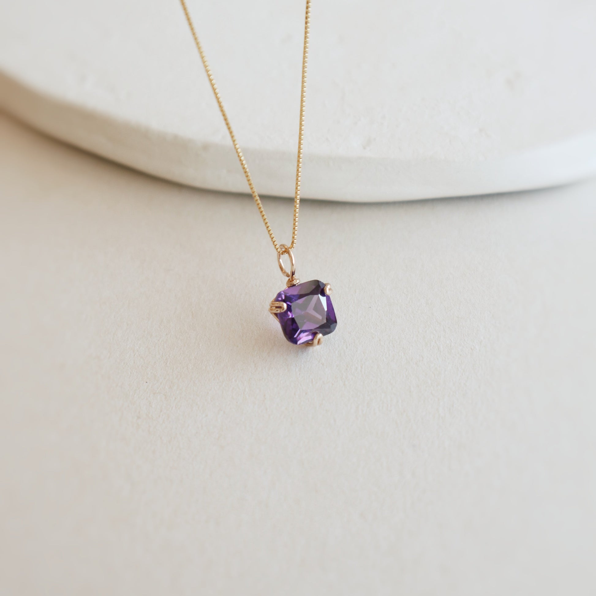 Necklace with a purple gemstone pendant on a white background